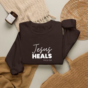 Black sweatshirt with 'Jesus Heals' text and Bible verse reference.