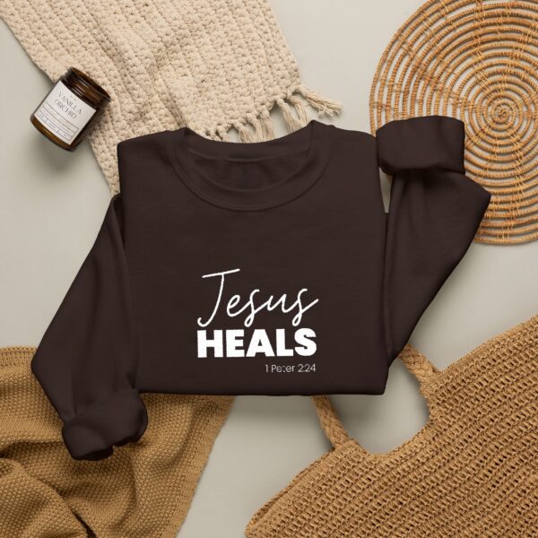 Black sweatshirt with 'Jesus Heals' text and Bible verse reference.