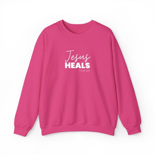 Pink sweatshirt with 'Jesus Heals' text and Bible verse reference.