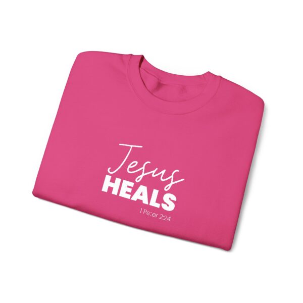 Pink crewneck sweatshirt with 'Jesus Heals' and Bible verse 1 Peter 2:24.